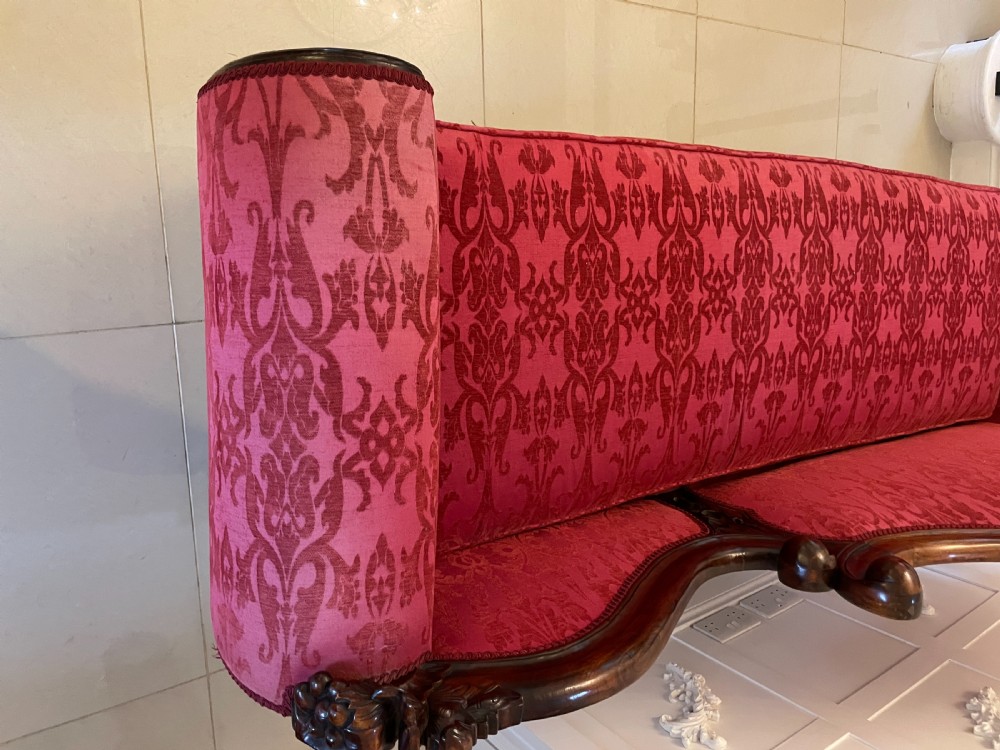 A Victorian carved mahogany chaise longue upholstered in patterned red damask fabric featuring an asymmetrical backrest and carved cabriole legs. View XI