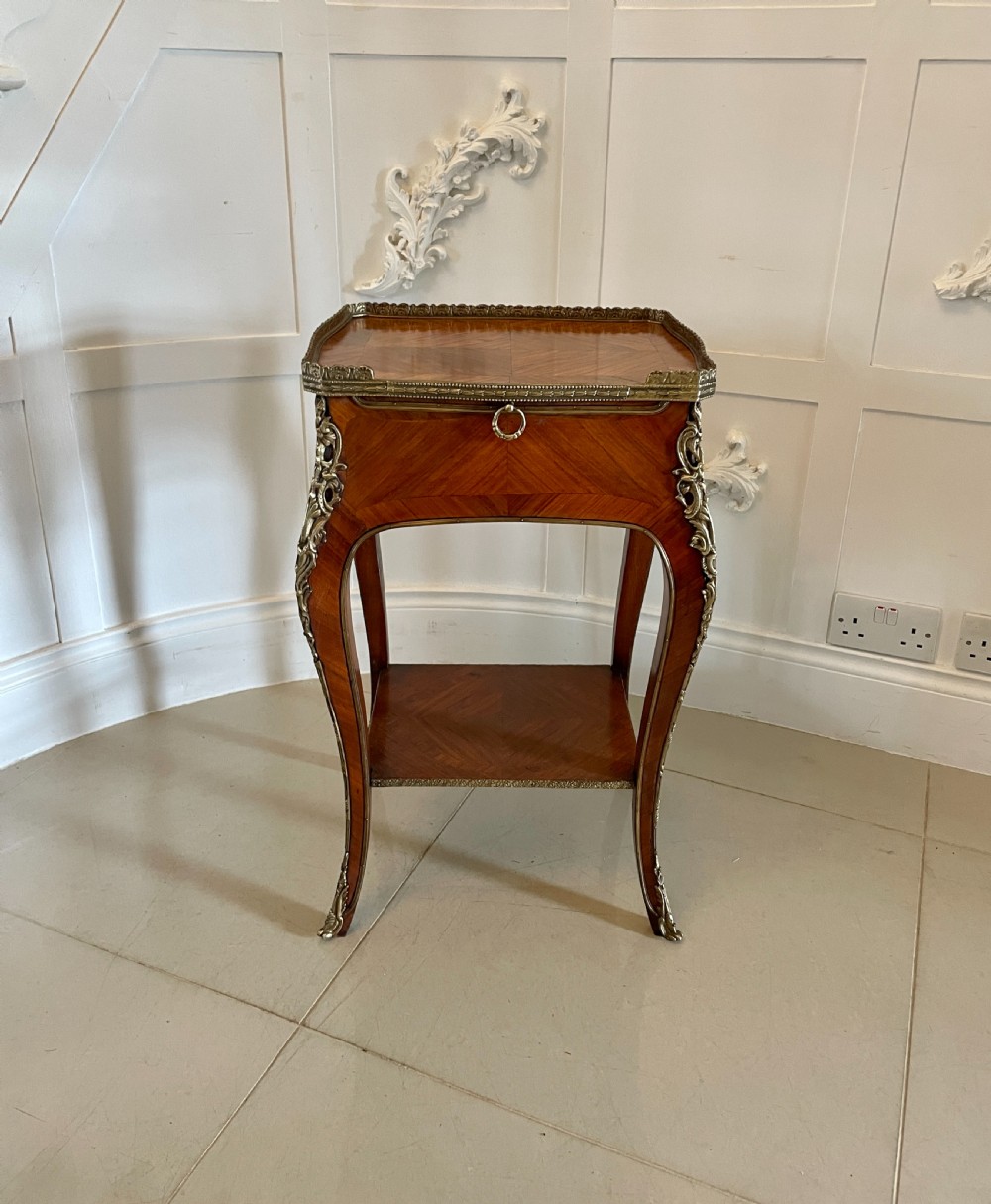 A French-style kingwood lamp table featuring geometric parquetry veneer, gilt-bronze ormolu mounts on cabriole legs, a pierced brass gallery rail, and an undertier shelf.