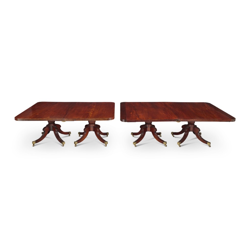 An exceptionally long antique mahogany Regency dining table supported by four reeded pedestal bases with brass castors. View III
