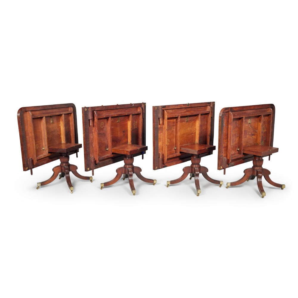 An exceptionally long antique mahogany Regency dining table supported by four reeded pedestal bases with brass castors. View V