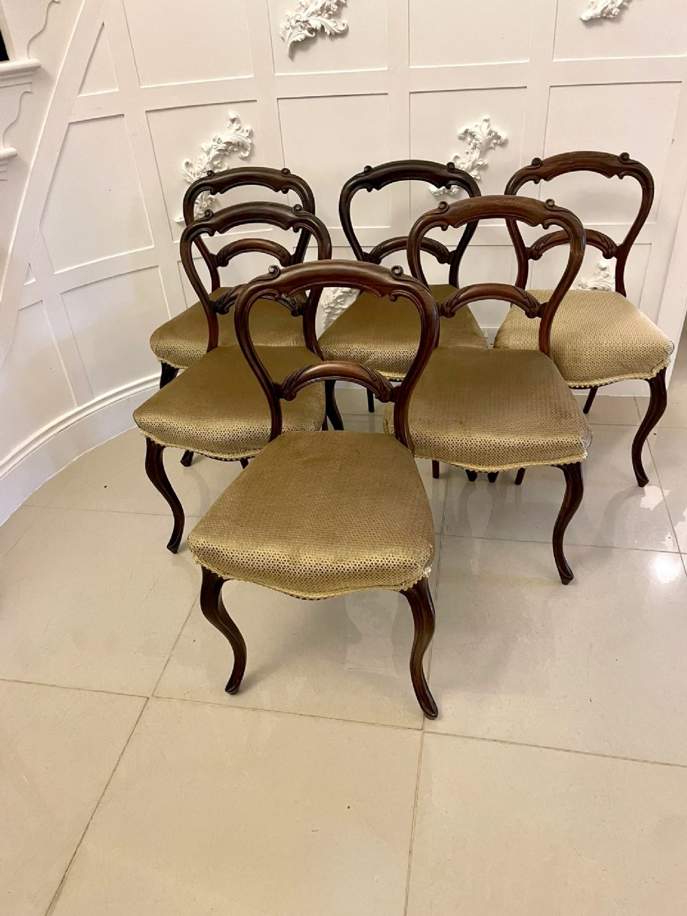 A set of six Victorian rosewood balloon back dining chairs with carved mid-rails, cabriole legs, and gold upholstered seats.