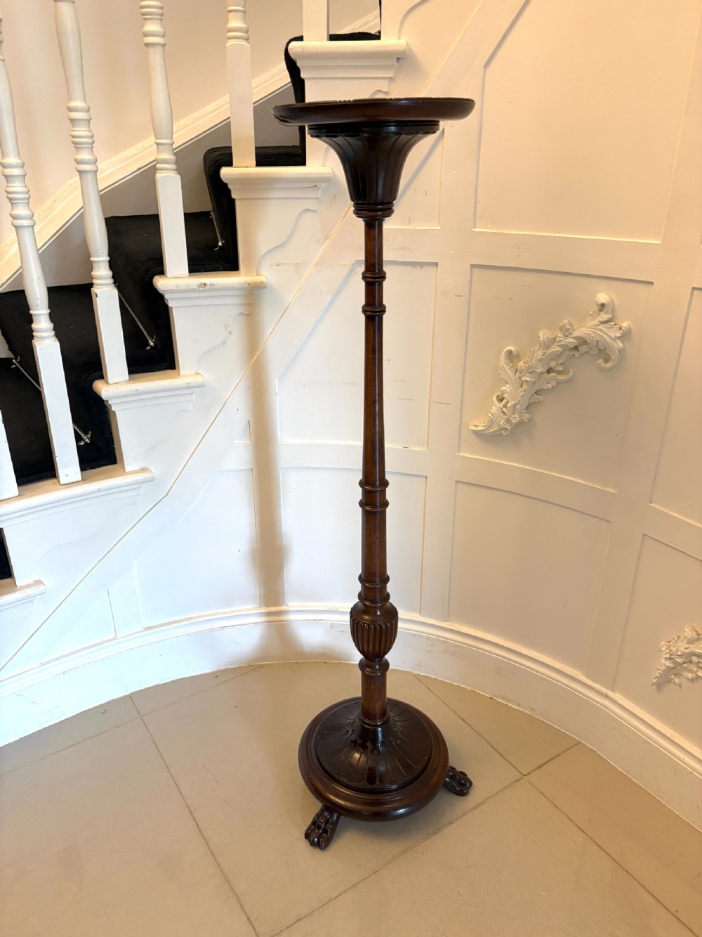 A tall Victorian carved mahogany torchere stand featuring a dish top, turned and fluted shaft, and a circular base with carved feet. View III
