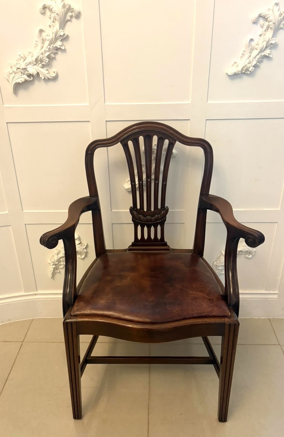 A set of Victorian mahogany Hepplewhite style dining chairs featuring shield-shaped backs with carved splats and tan leather upholstered seats. View III