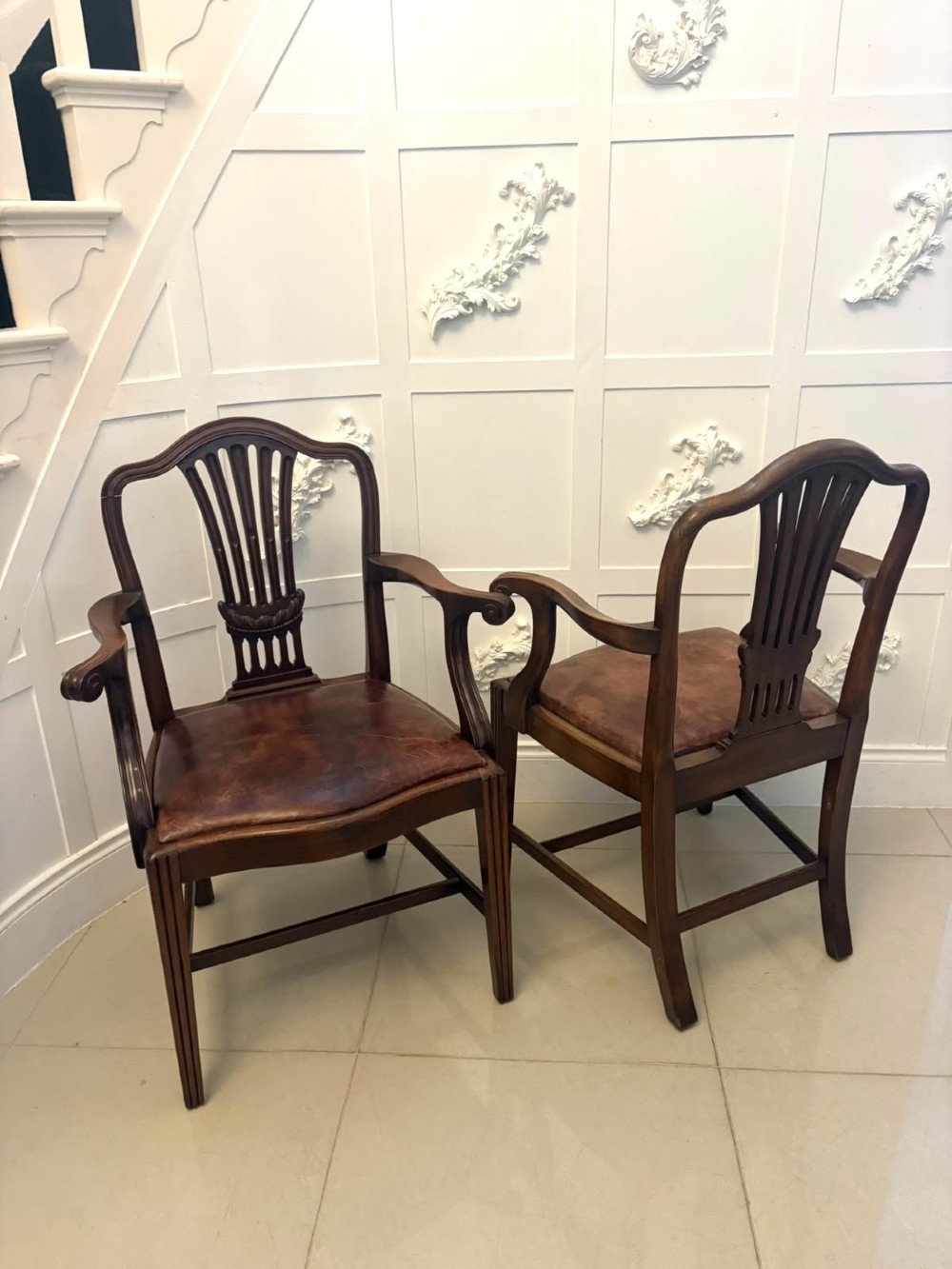 A set of Victorian mahogany Hepplewhite style dining chairs featuring shield-shaped backs with carved splats and tan leather upholstered seats. View IV