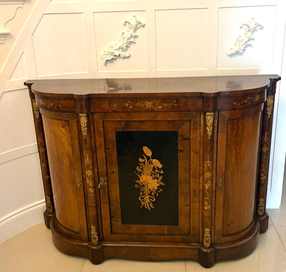 A nineteenth-century Victorian burr walnut credenza featuring curved side doors, intricate floral marquetry inlays, and gilt bronze mounts. View V