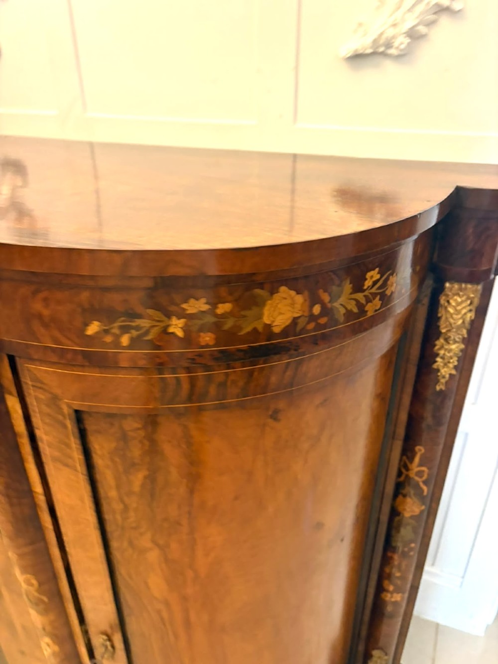 A nineteenth-century Victorian burr walnut credenza featuring curved side doors, intricate floral marquetry inlays, and gilt bronze mounts. View VI