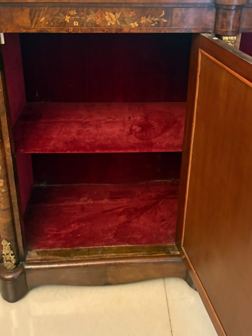 A nineteenth-century Victorian burr walnut credenza featuring curved side doors, intricate floral marquetry inlays, and gilt bronze mounts. View X