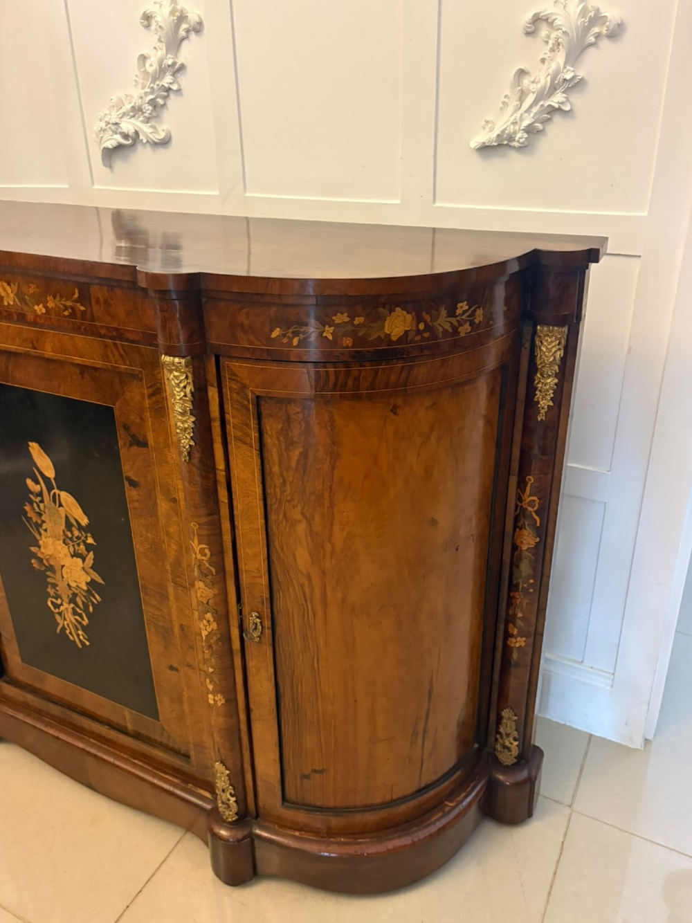 A nineteenth-century Victorian burr walnut credenza featuring curved side doors, intricate floral marquetry inlays, and gilt bronze mounts. View XII