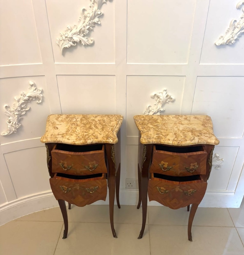 A pair of French Louis XV style kingwood bedside cabinets featuring floral marquetry inlays, gilt bronze mounts, serpentine fronts, and shaped marble tops. View VI