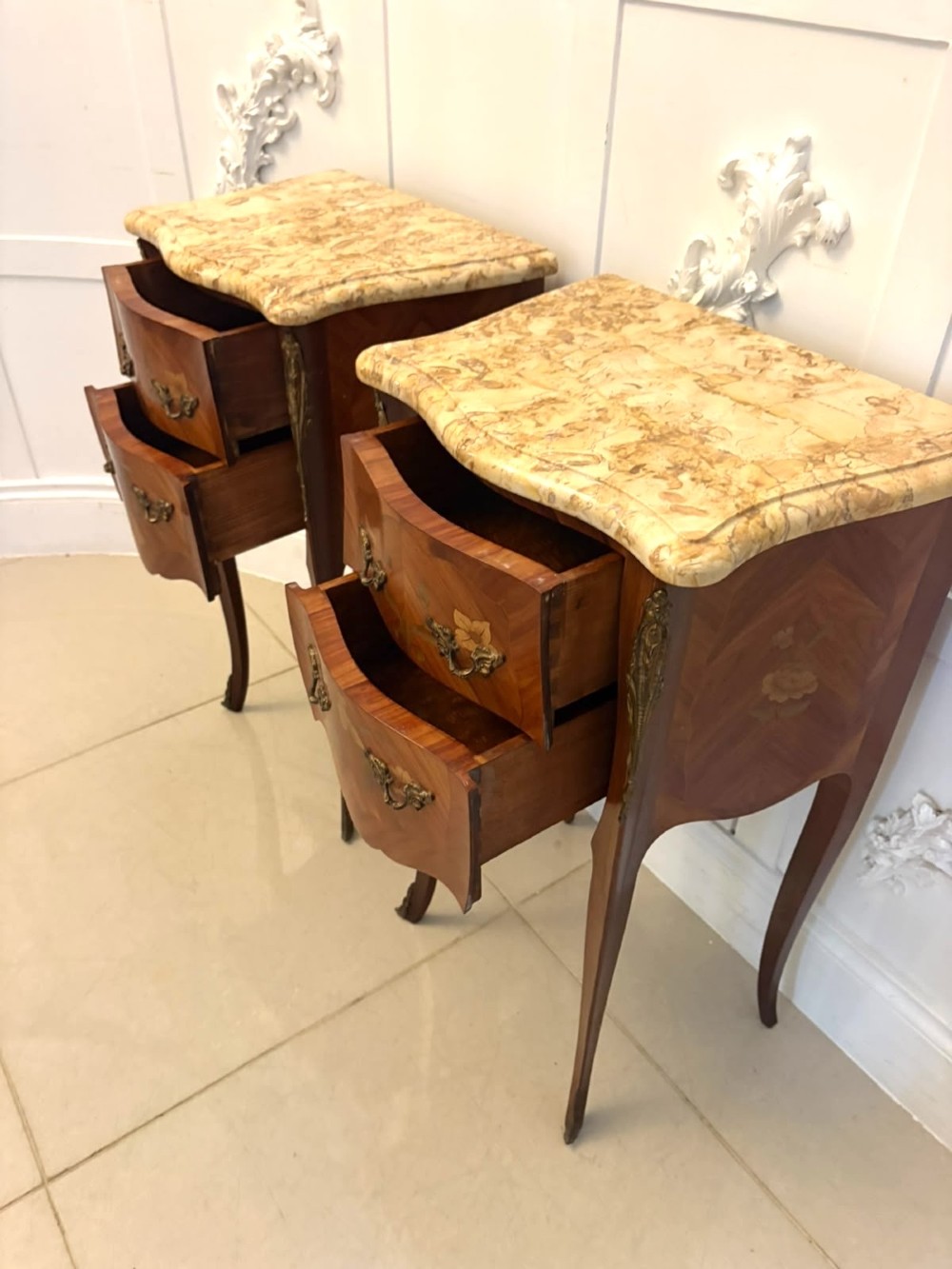 A pair of French Louis XV style kingwood bedside cabinets featuring floral marquetry inlays, gilt bronze mounts, serpentine fronts, and shaped marble tops. View VIII