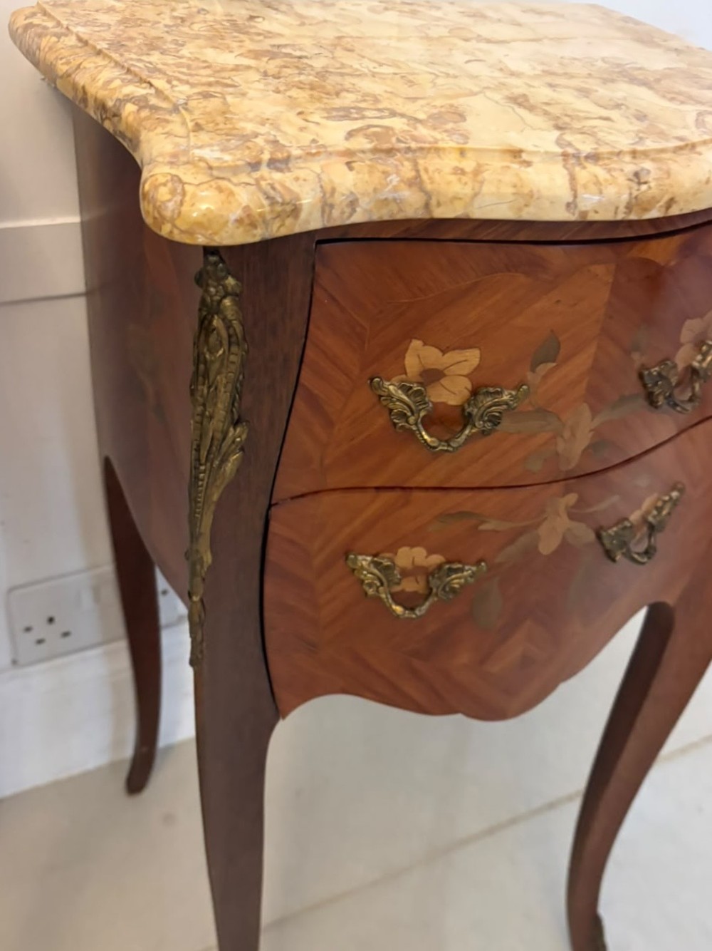 A pair of French Louis XV style kingwood bedside cabinets featuring floral marquetry inlays, gilt bronze mounts, serpentine fronts, and shaped marble tops. View XIII