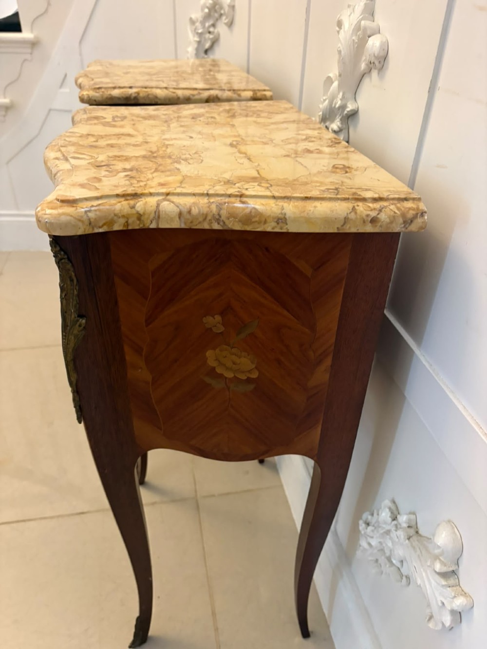 A pair of French Louis XV style kingwood bedside cabinets featuring floral marquetry inlays, gilt bronze mounts, serpentine fronts, and shaped marble tops. View XIV