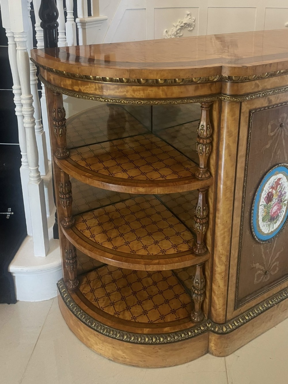 A large Victorian satinwood credenza featuring central glazed doors, oval porcelain plaques, and open curved side shelves. View IX
