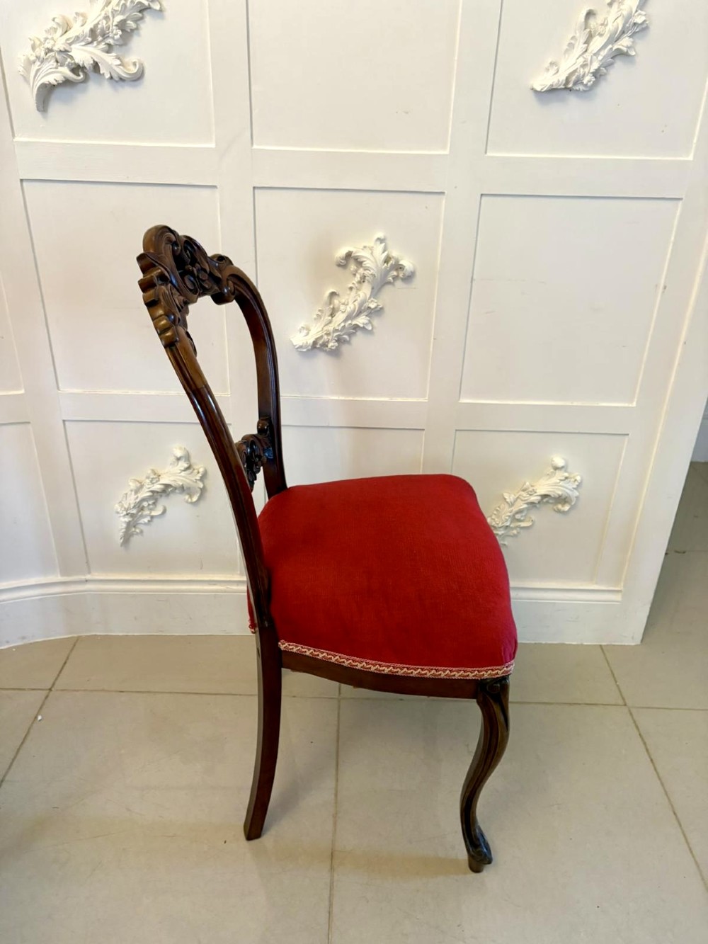 A set of Victorian carved mahogany dining chairs featuring open balloon-style backs and red velvet upholstered seats. View VI