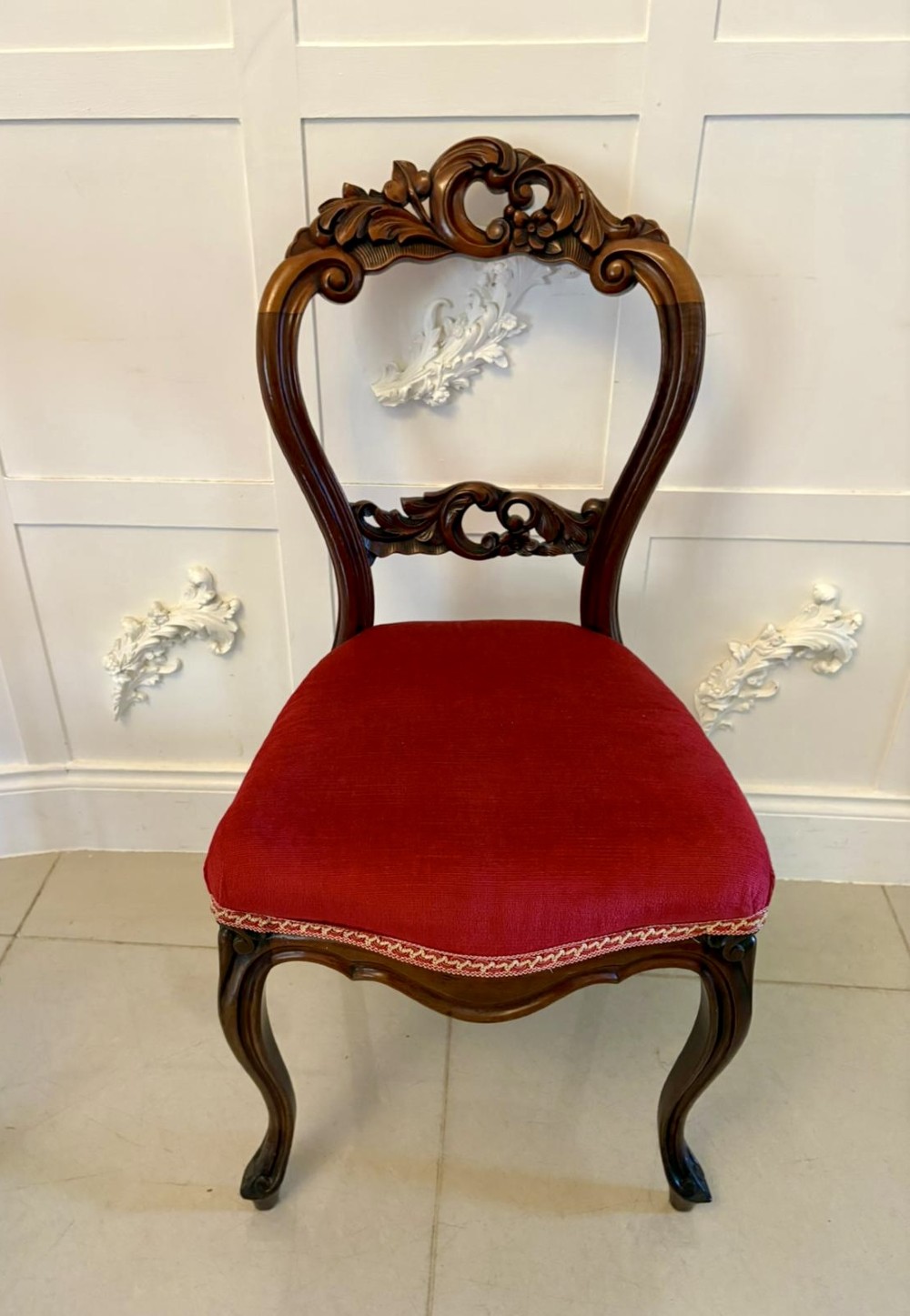 A set of Victorian carved mahogany dining chairs featuring open balloon-style backs and red velvet upholstered seats. View VIII