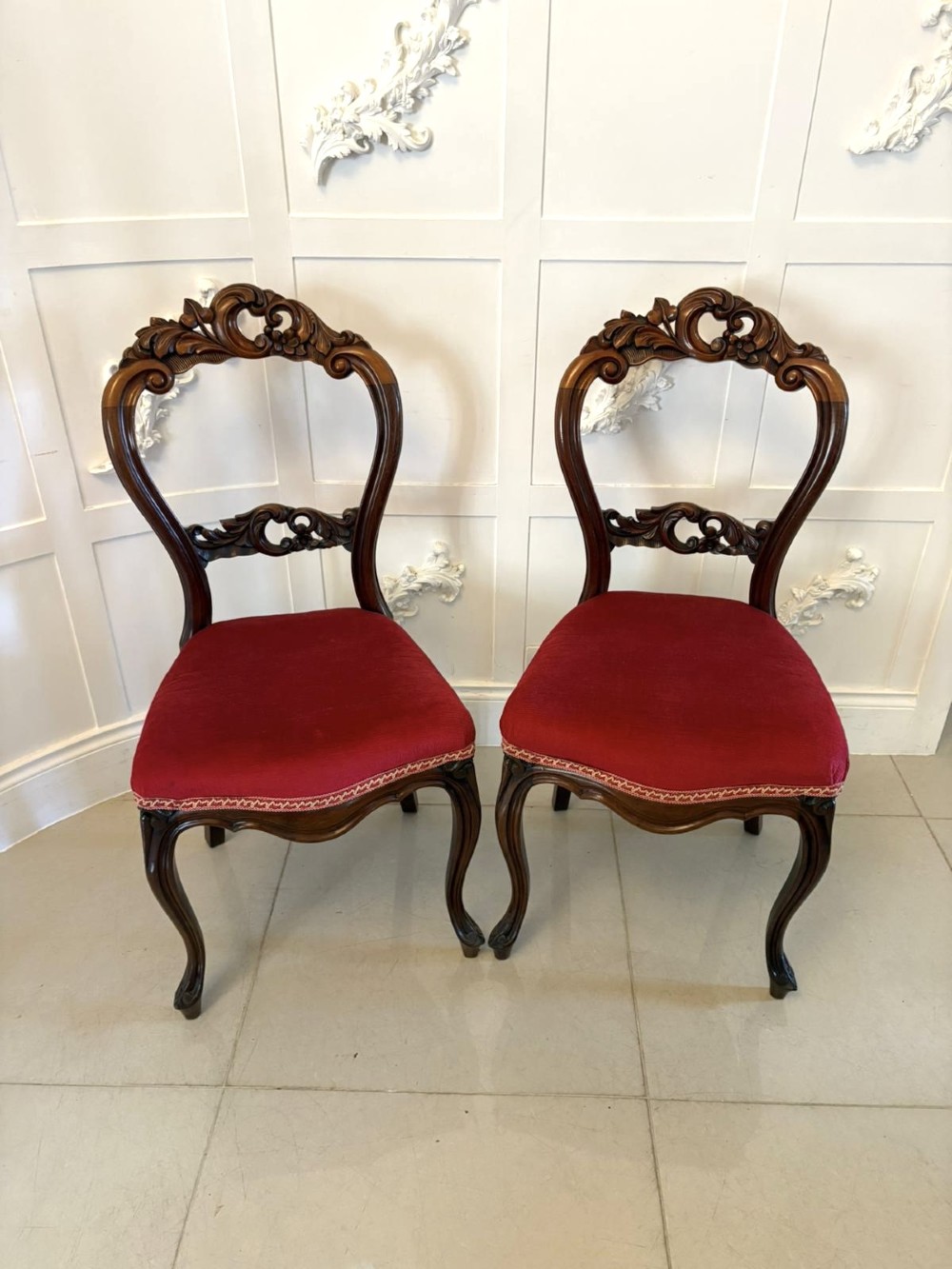 A set of Victorian carved mahogany dining chairs featuring open balloon-style backs and red velvet upholstered seats. View IX