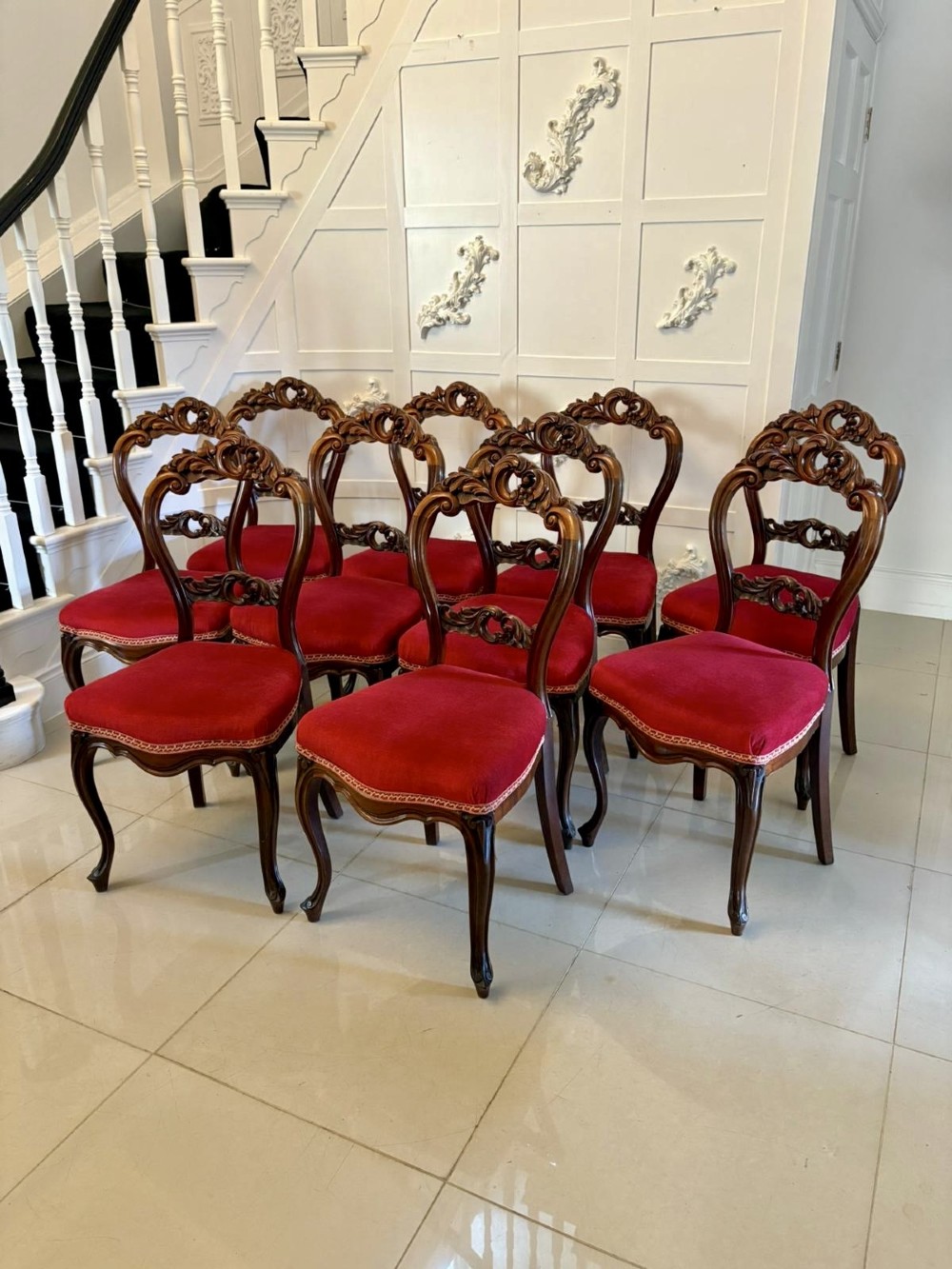A set of Victorian carved mahogany dining chairs featuring open balloon-style backs and red velvet upholstered seats. View X