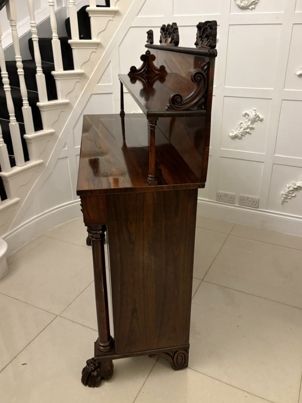 A dark mahogany Regency chiffonier sideboard featuring a two-door lower cupboard, turned support columns, carved claw feet, and a raised upper display shelf with a carved scroll cresting. View III