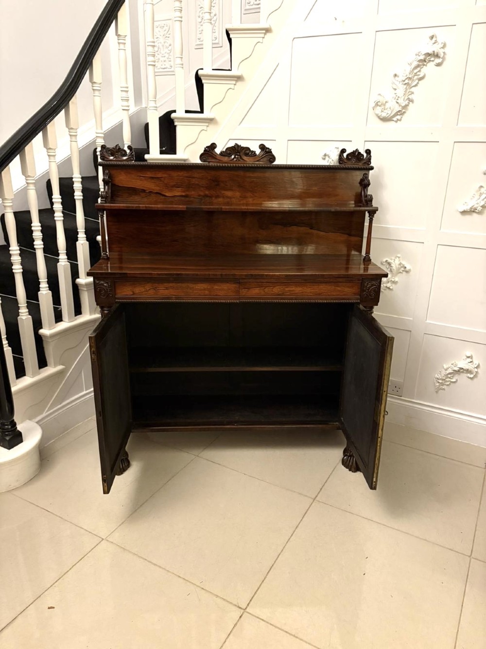 A dark mahogany Regency chiffonier sideboard featuring a two-door lower cupboard, turned support columns, carved claw feet, and a raised upper display shelf with a carved scroll cresting. View VII