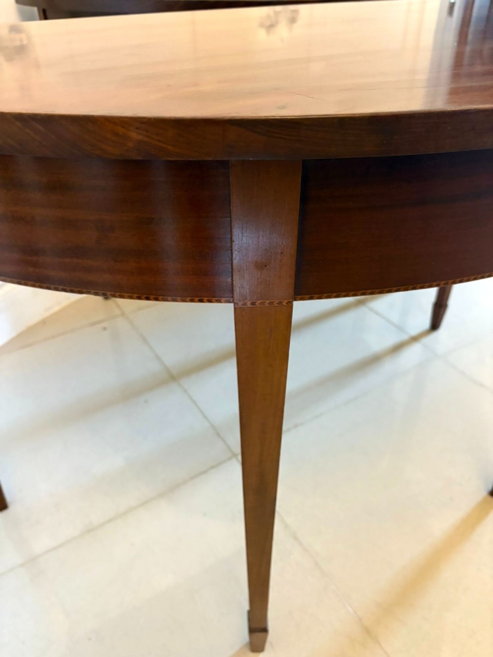 A pair of George III mahogany demi-lune console tables with polished semi-circular tops and tapered square legs. View V