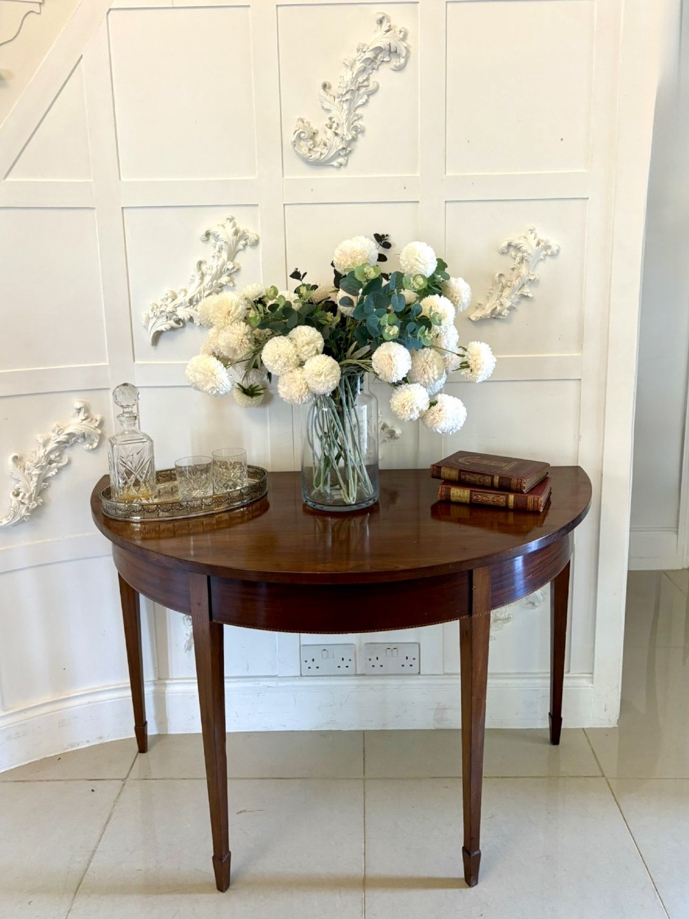 A pair of George III mahogany demi-lune console tables with polished semi-circular tops and tapered square legs. View VI