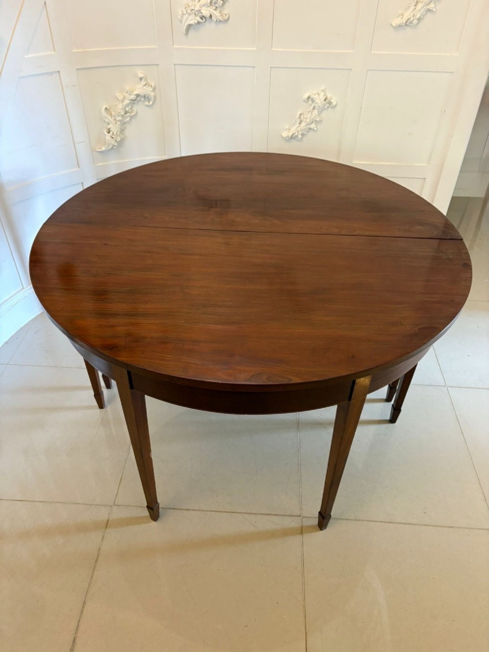 A pair of George III mahogany demi-lune console tables with polished semi-circular tops and tapered square legs. View IX