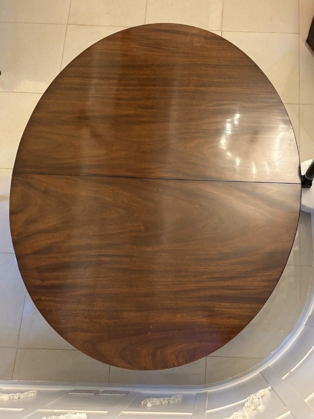 An antique oval extending mahogany dining table on splayed pedestal legs with brass castors. View IX