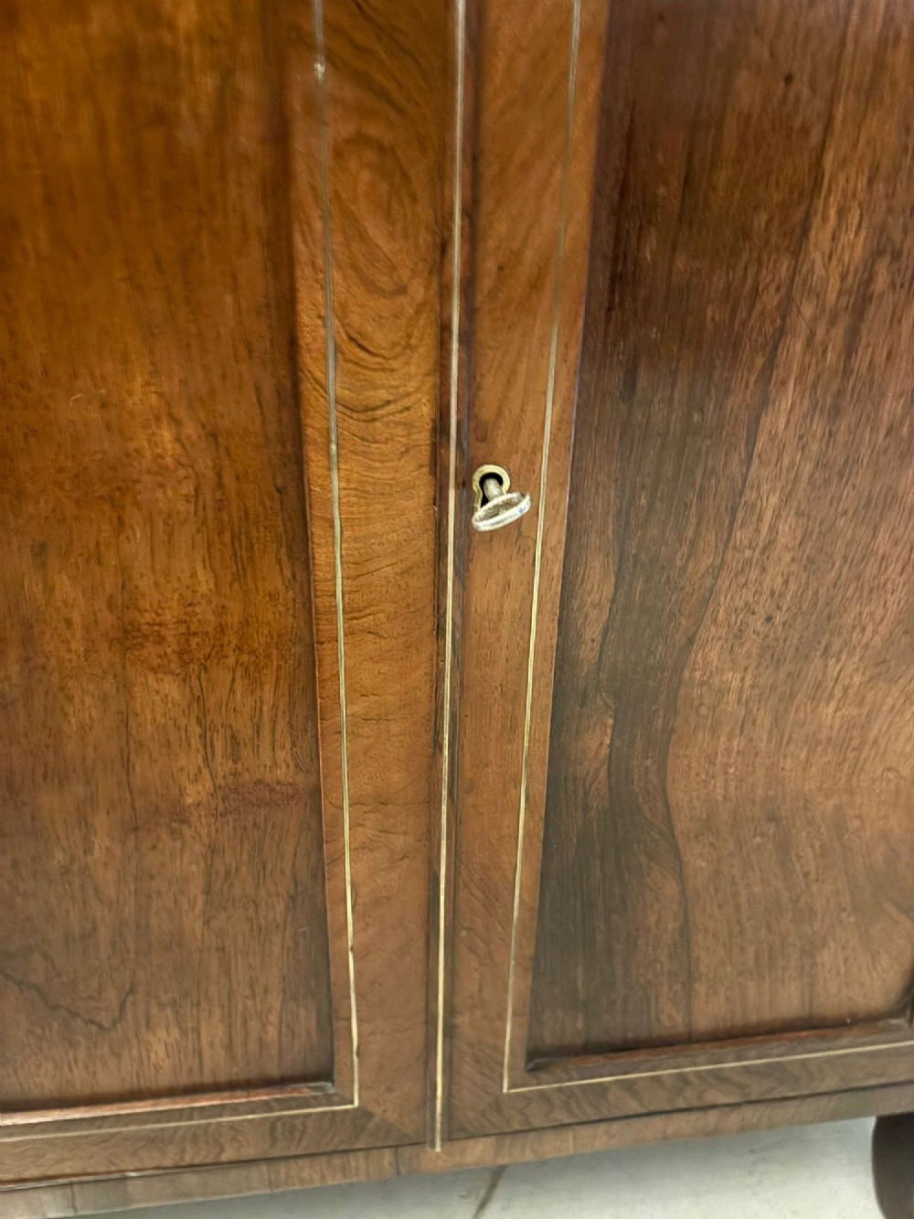 An antique Regency mahogany chiffonier side cabinet featuring intricate floral brass inlay on the doors and frieze with an upper open shelf. View IV