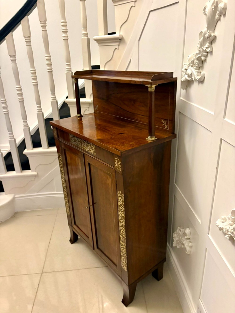 An antique Regency mahogany chiffonier side cabinet featuring intricate floral brass inlay on the doors and frieze with an upper open shelf. View VII