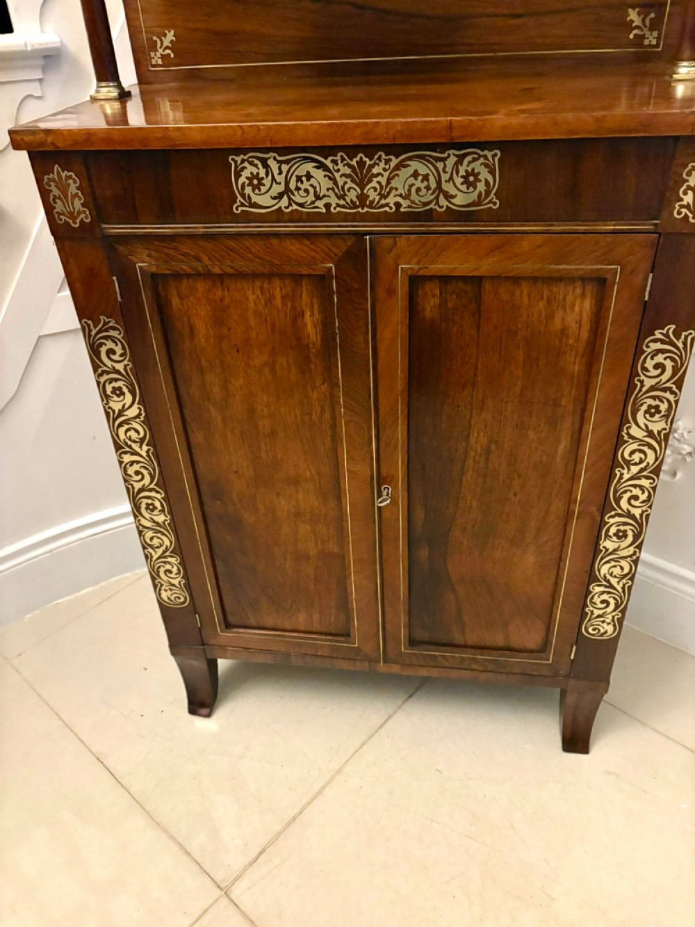 An antique Regency mahogany chiffonier side cabinet featuring intricate floral brass inlay on the doors and frieze with an upper open shelf. View IX