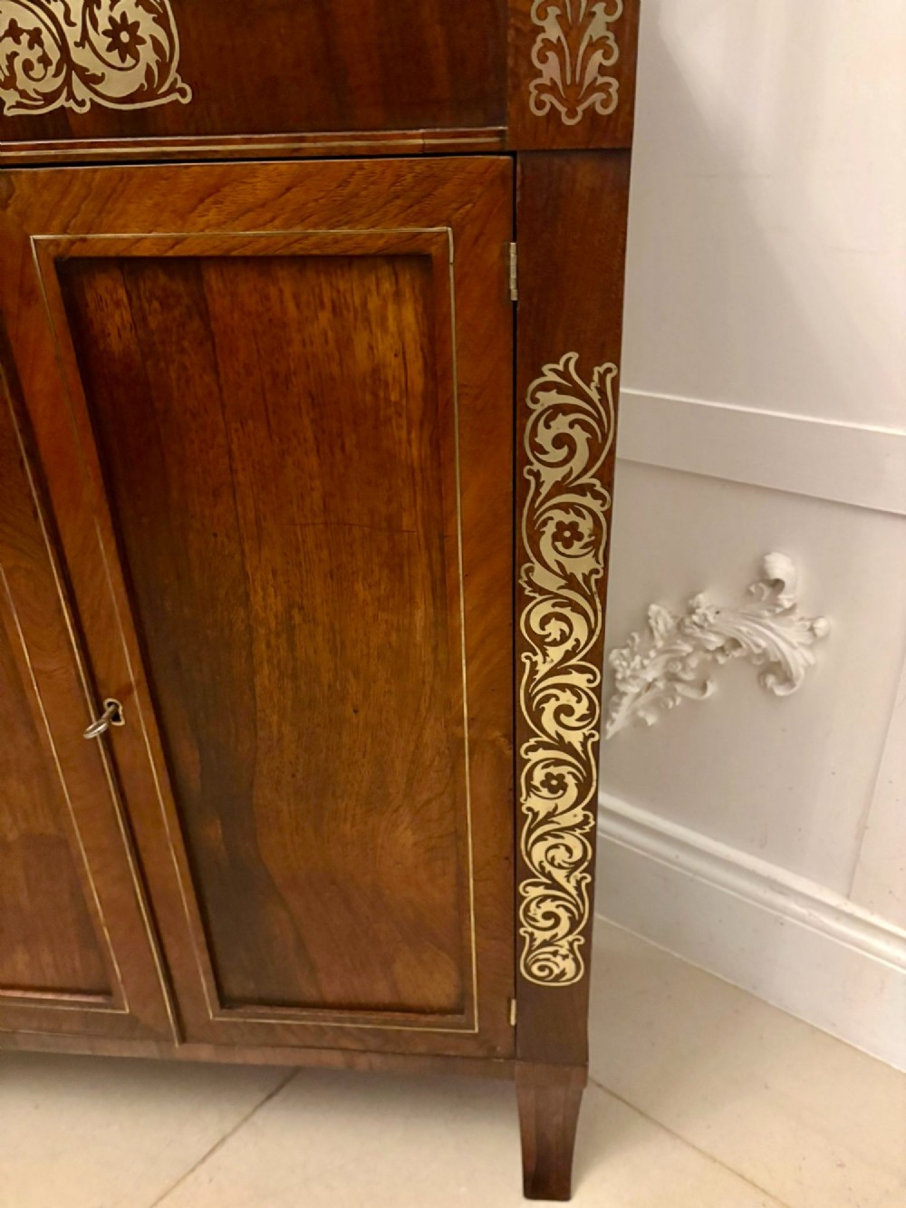 An antique Regency mahogany chiffonier side cabinet featuring intricate floral brass inlay on the doors and frieze with an upper open shelf. View X