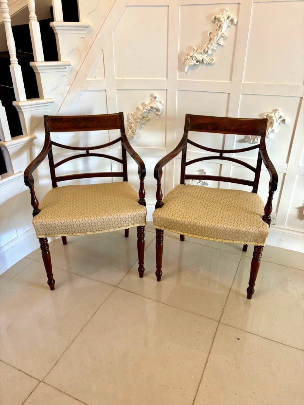 A set of eight George III style mahogany dining chairs featuring two carvers and six side chairs with reeded frames and patterned cream upholstered seats. View IV