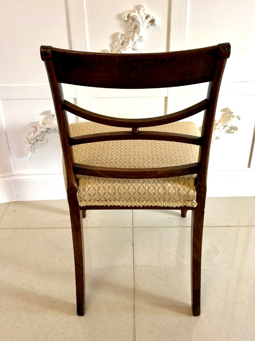 A set of eight George III style mahogany dining chairs featuring two carvers and six side chairs with reeded frames and patterned cream upholstered seats. View VI