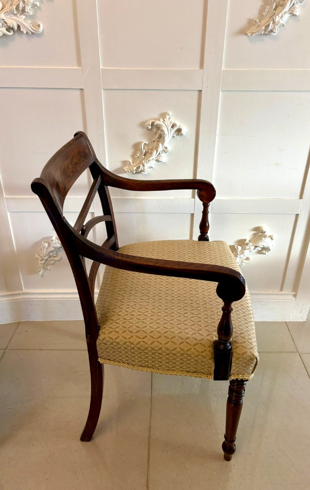 A set of eight George III style mahogany dining chairs featuring two carvers and six side chairs with reeded frames and patterned cream upholstered seats. View VII