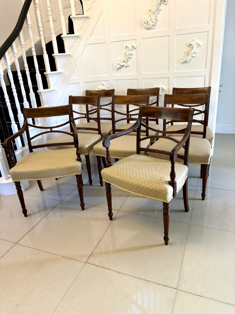 A set of eight George III style mahogany dining chairs featuring two carvers and six side chairs with reeded frames and patterned cream upholstered seats. View XIV