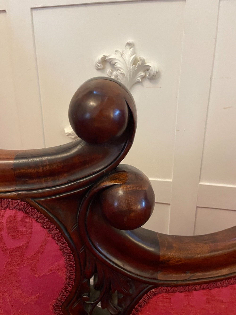 An antique Victorian carved mahogany chaise longue upholstered in deep red damask fabric with cabriole legs and ornate timber carving. View VII