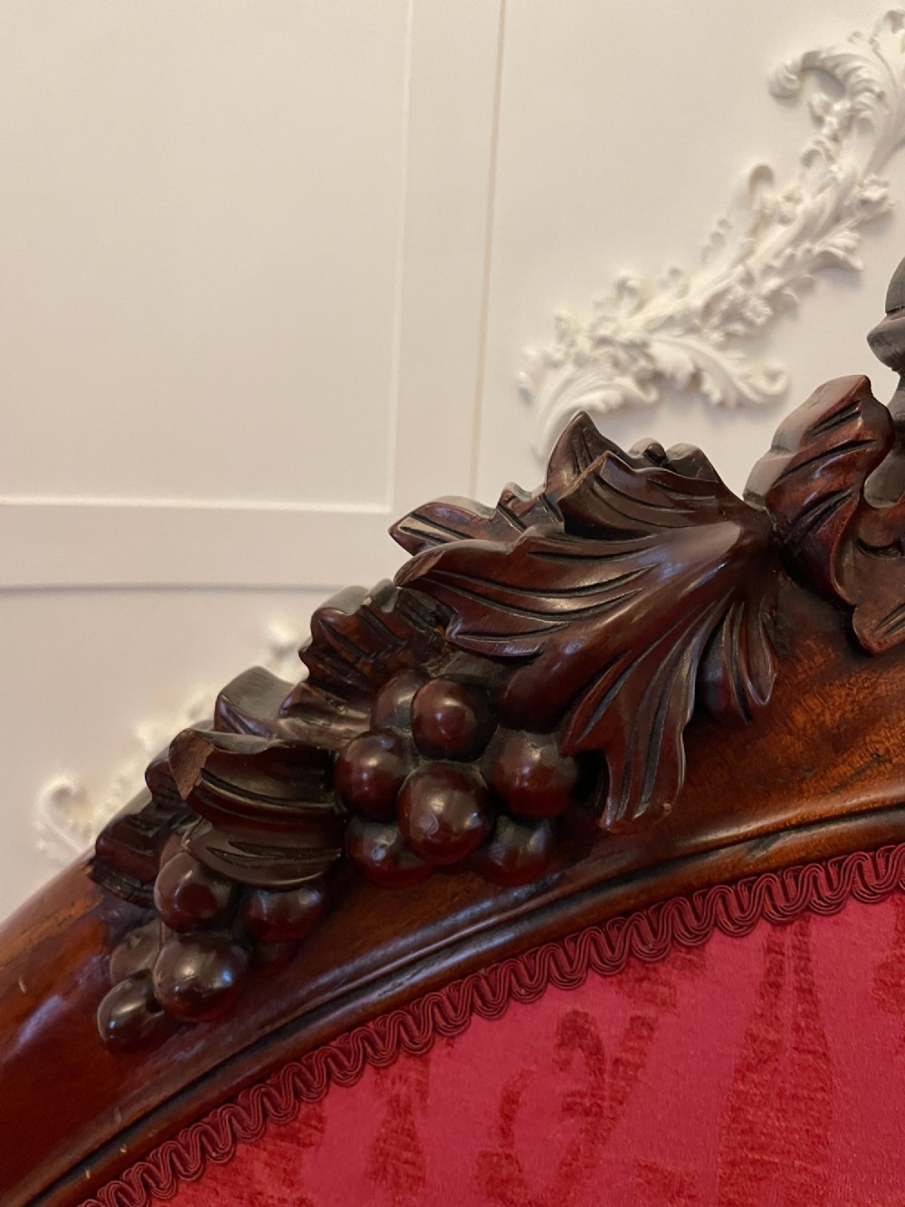 An antique Victorian carved mahogany chaise longue upholstered in deep red damask fabric with cabriole legs and ornate timber carving. View VIII