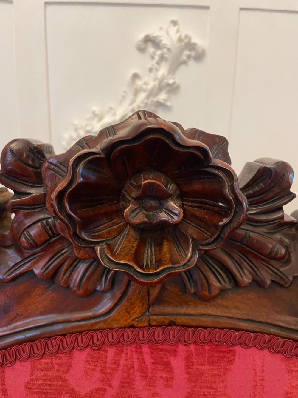 An antique Victorian carved mahogany chaise longue upholstered in deep red damask fabric with cabriole legs and ornate timber carving. View IX