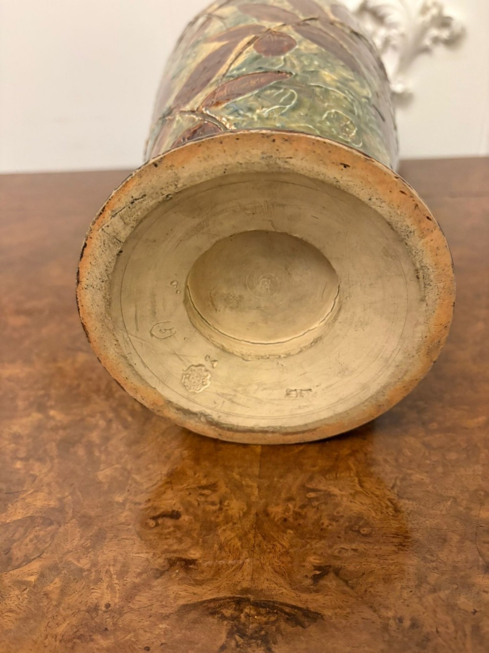 A tall Victorian glazed stoneware vase featuring a mottled green background decorated with brown leaf impressions and a flared rim. View VII