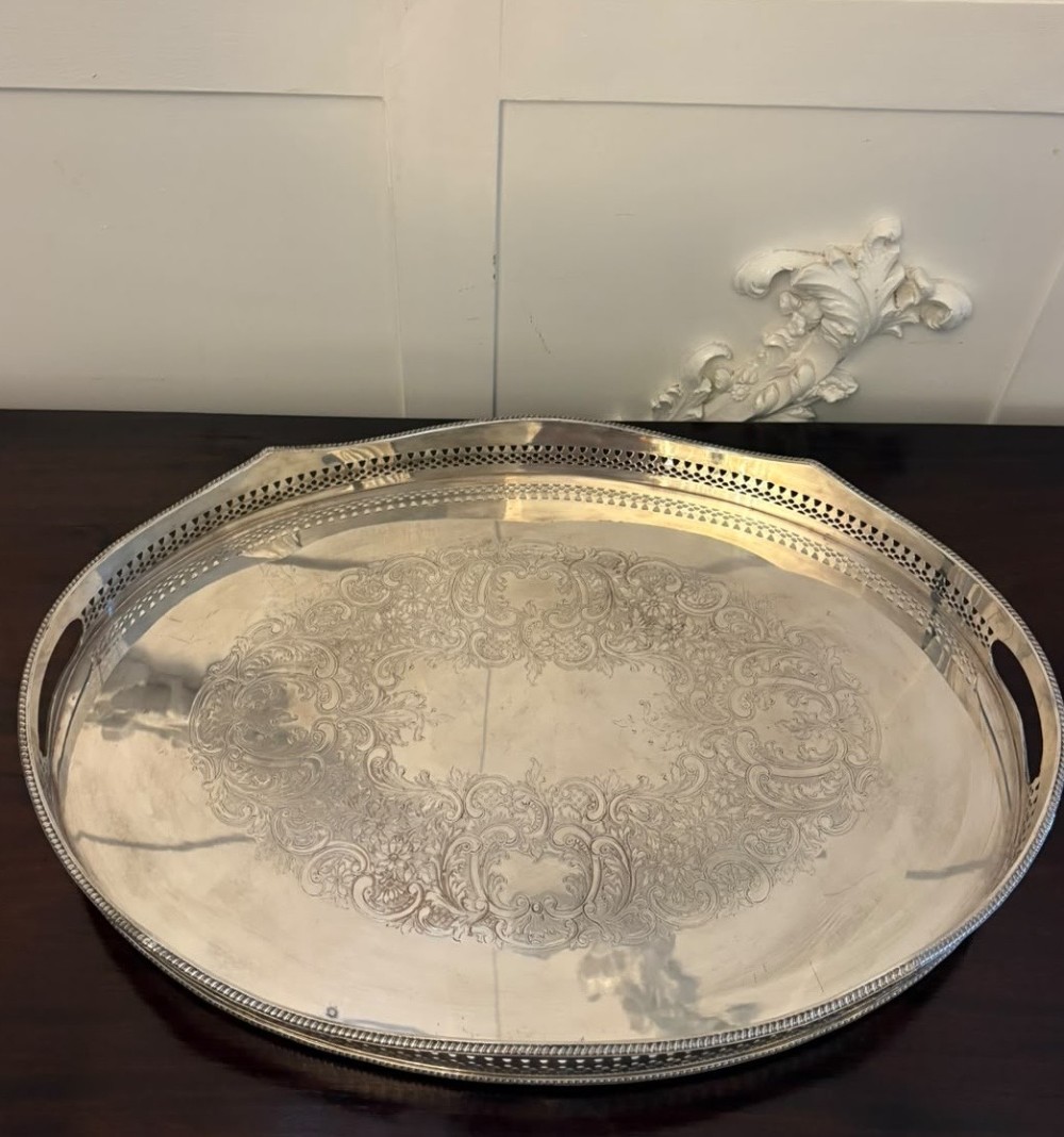An oval Edwardian silver plated serving tray with an engraved foliate surface pattern and a pierced gallery border featuring cut-out hand grips. View XII