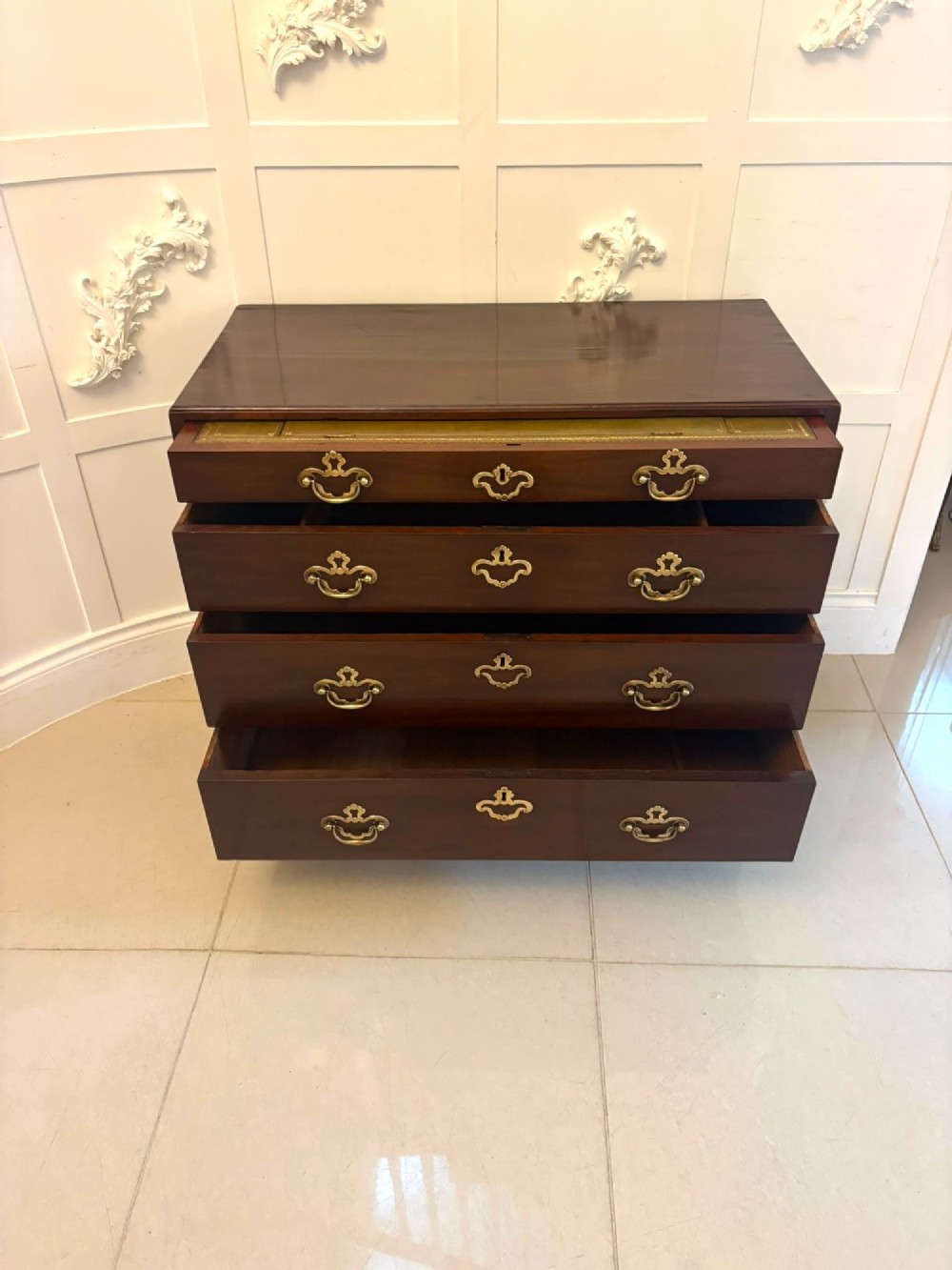 A George II mahogany chest of drawers featuring an open top writing drawer with an adjustable gilt-tooled green leather surface and brass handles. View VII