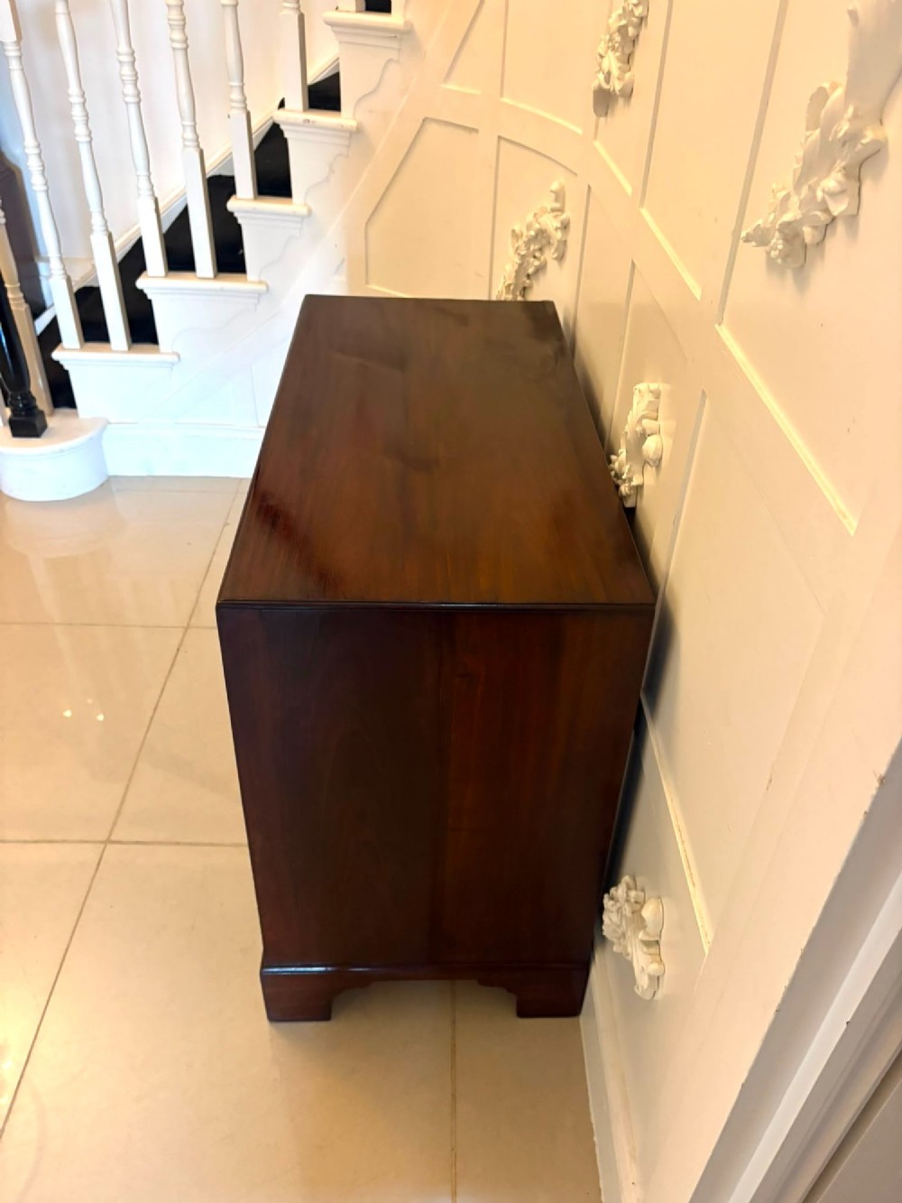 A George II mahogany chest of drawers featuring an open top writing drawer with an adjustable gilt-tooled green leather surface and brass handles. View VIII