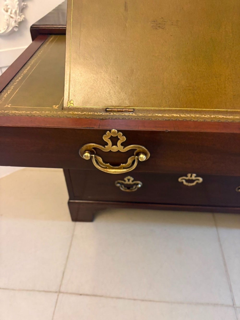 A George II mahogany chest of drawers featuring an open top writing drawer with an adjustable gilt-tooled green leather surface and brass handles. View XII