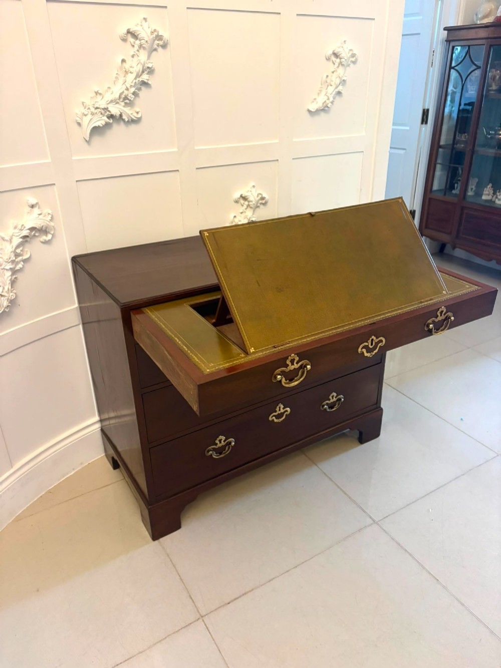 A George II mahogany chest of drawers featuring an open top writing drawer with an adjustable gilt-tooled green leather surface and brass handles. View XIII