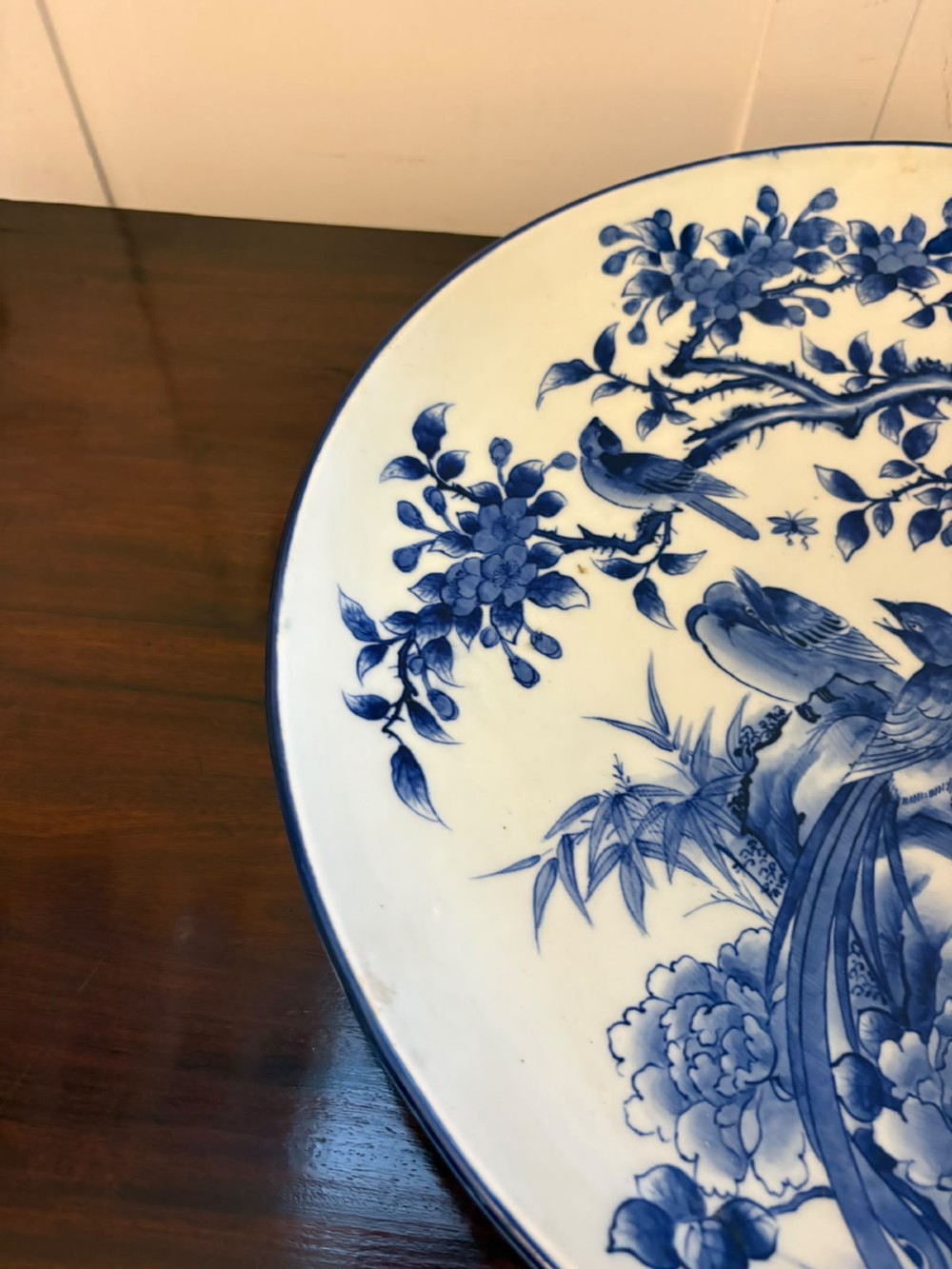 A pair of large circular blue and white Chinese porcelain chargers decorated with hand-painted birds and flowering branches. View V