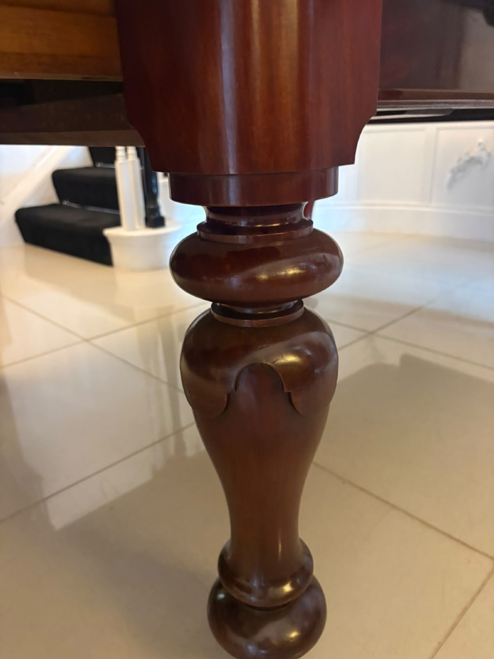 A large William IV figured mahogany extending dining table with a polished surface, rounded corners, and turned legs on brass castors. View VI