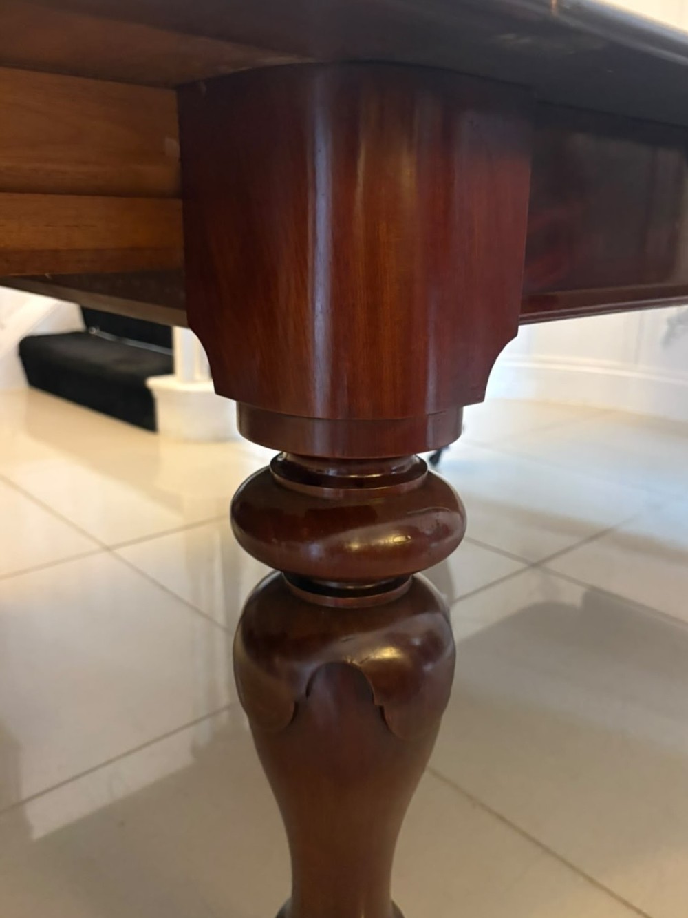 A large William IV figured mahogany extending dining table with a polished surface, rounded corners, and turned legs on brass castors. View VII