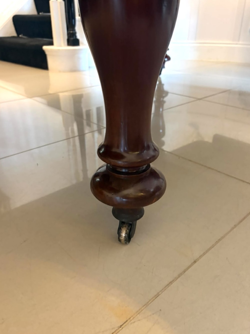 A large William IV figured mahogany extending dining table with a polished surface, rounded corners, and turned legs on brass castors. View VIII