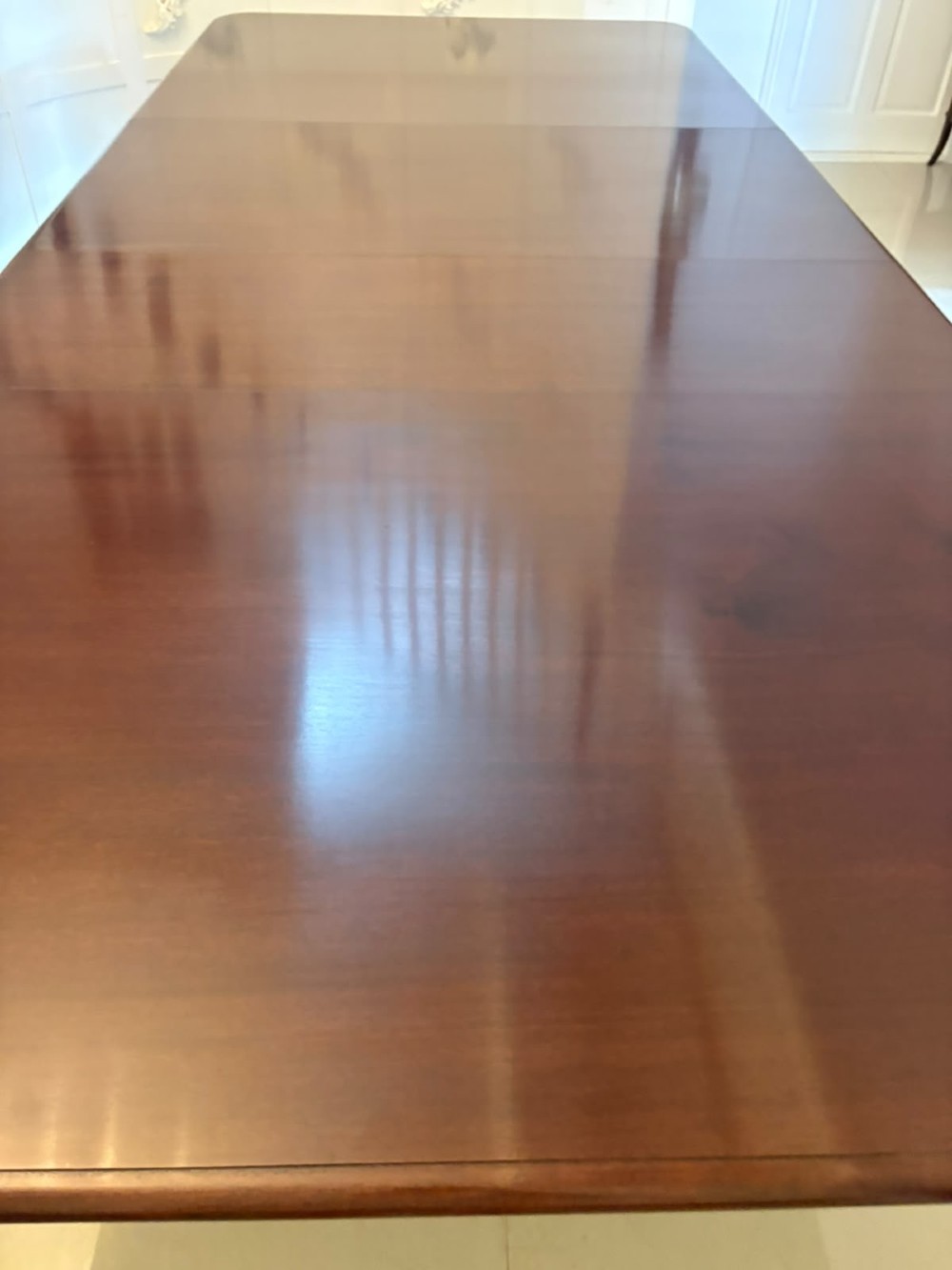 A large William IV figured mahogany extending dining table with a polished surface, rounded corners, and turned legs on brass castors. View IX