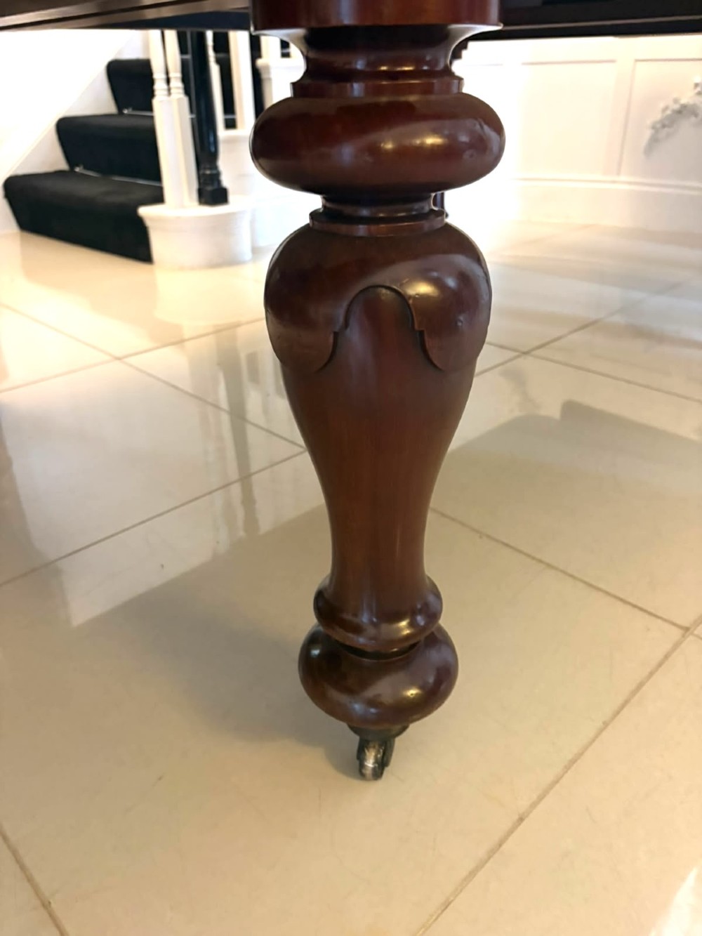A large William IV figured mahogany extending dining table with a polished surface, rounded corners, and turned legs on brass castors. View X